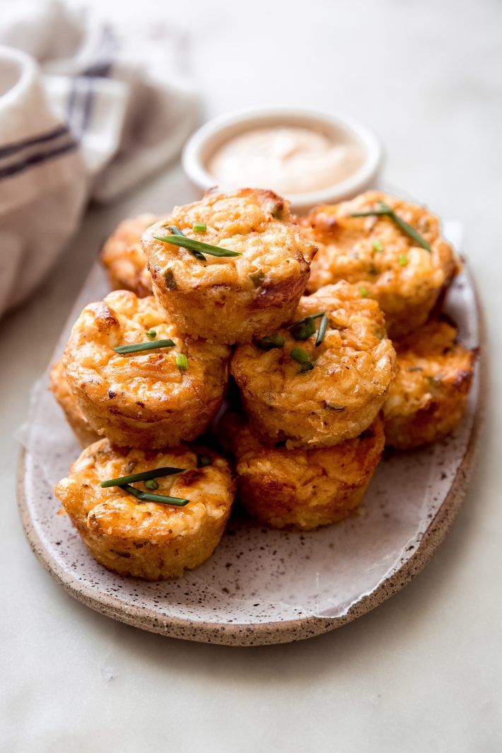 crab cake bites on a speckled tray on white marble surface