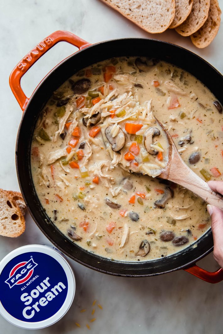 soup in dutch oven with FAGE sour cream product on white marble surface