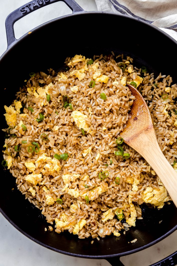 wooden spoon in cast iron skillet with fried rice