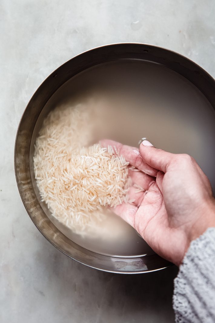 hand in bowl with soaked basmati rice