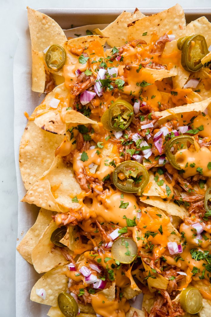 close up of prepared nachos with melted queso and cilantro 