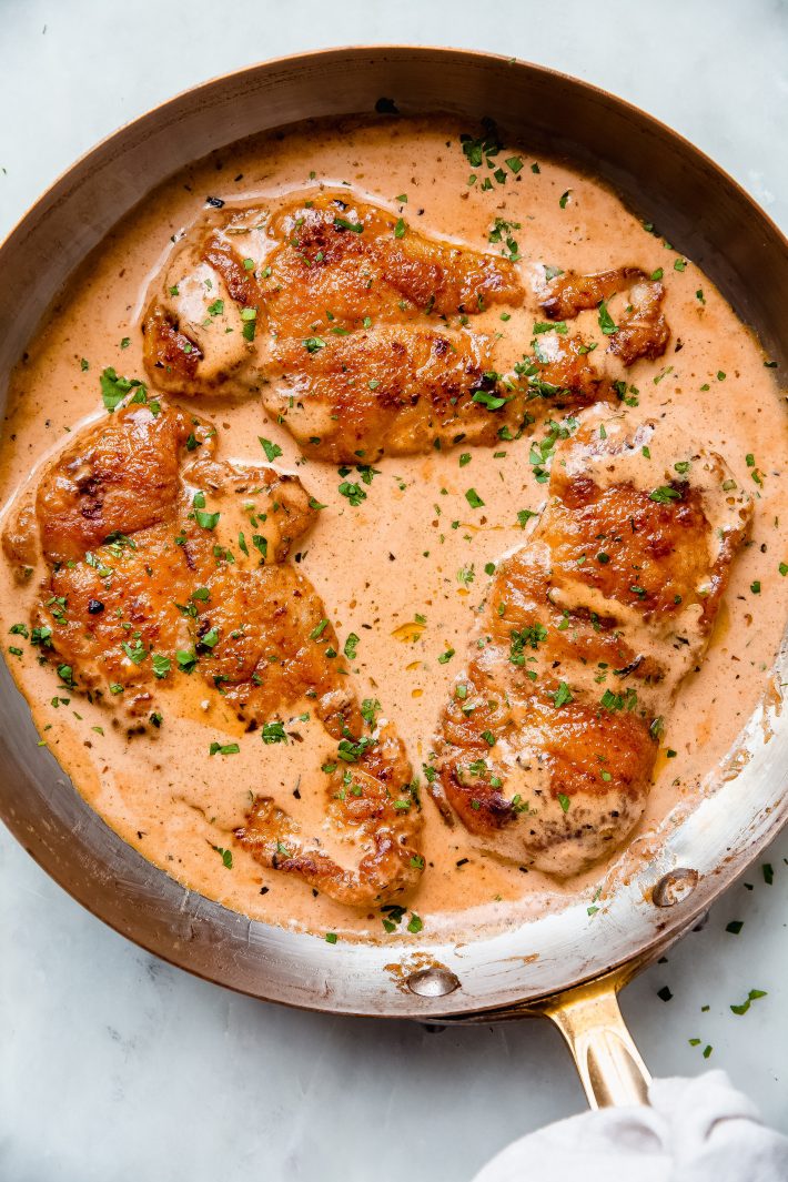 chicken lazone in a skillet on white marble