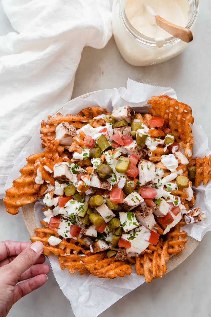 waffle fries topped with shawarma chicken, pickles, tomatoes, and homemade garlic sauce
