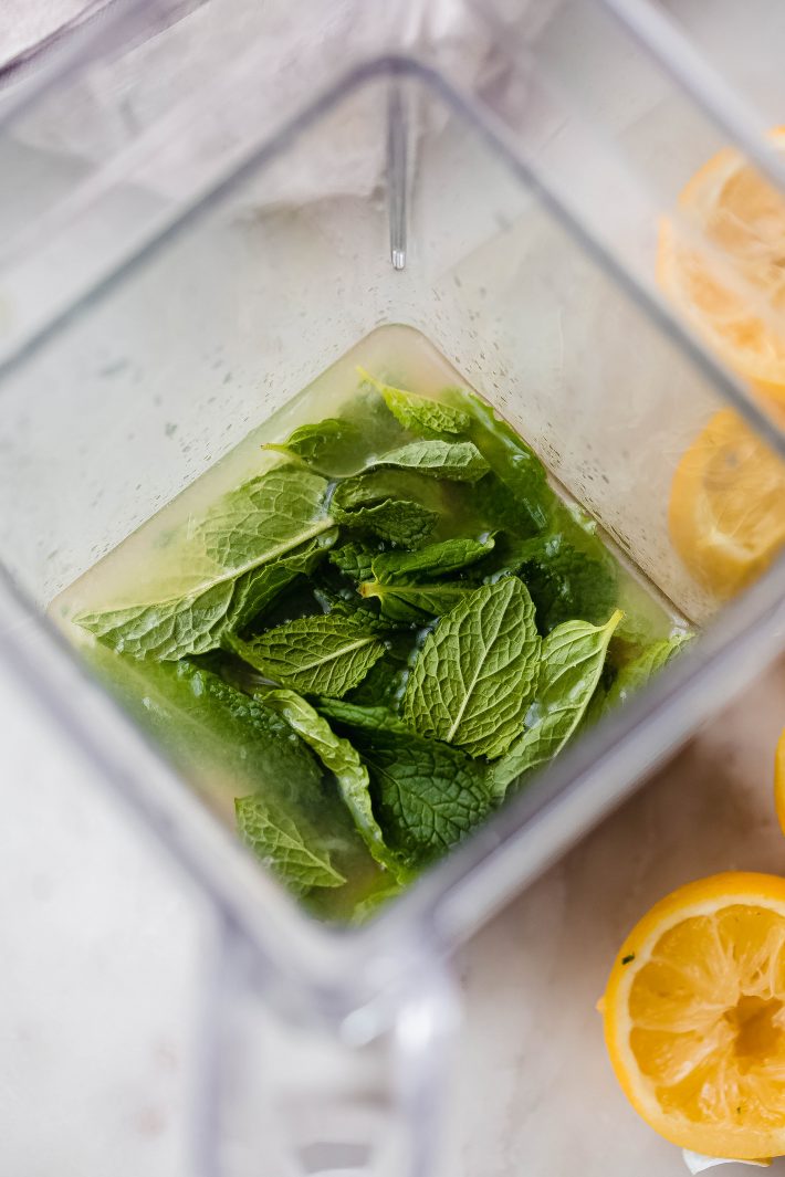 fresh mint leaves in blender with lemon and sugar