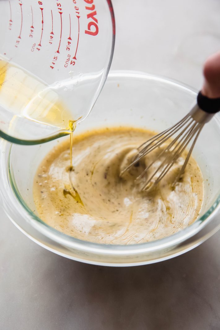 whisking Italian dressing in clear bowl