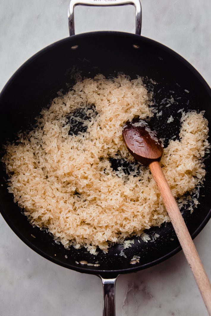 sautéed rice in pan with wooden spoon