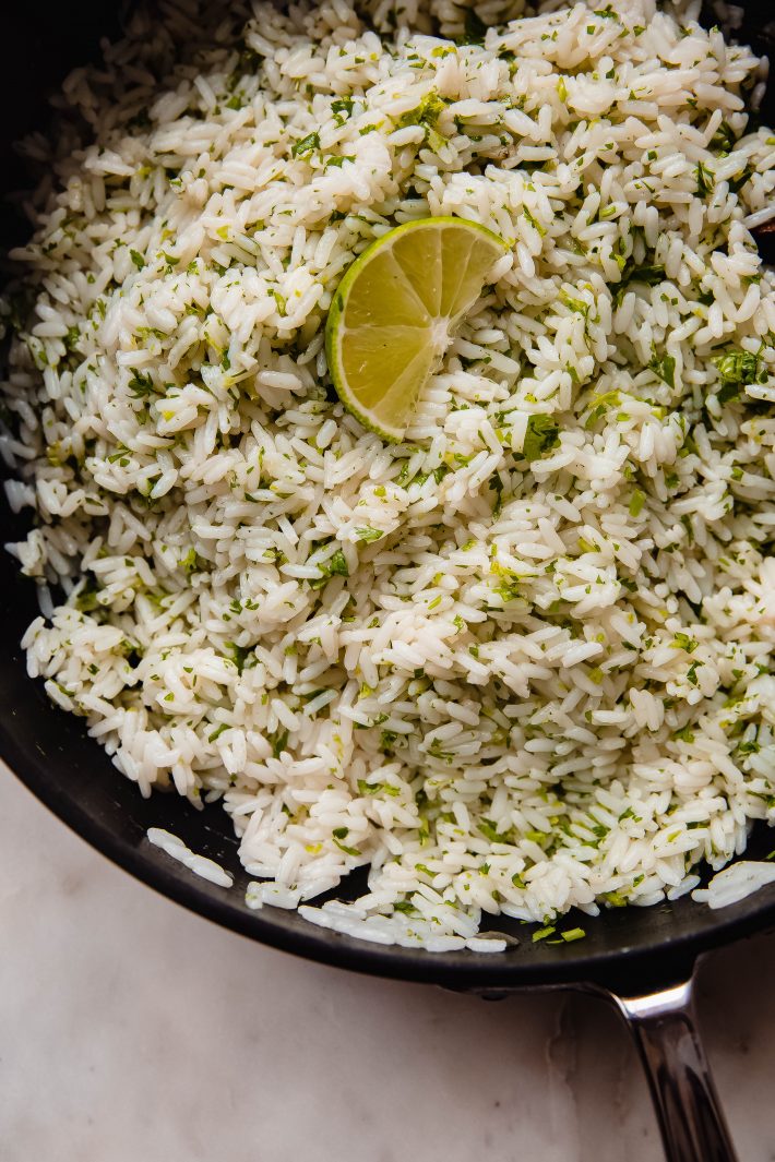 saute pan with prepared cilantro lime rice and lime wedge