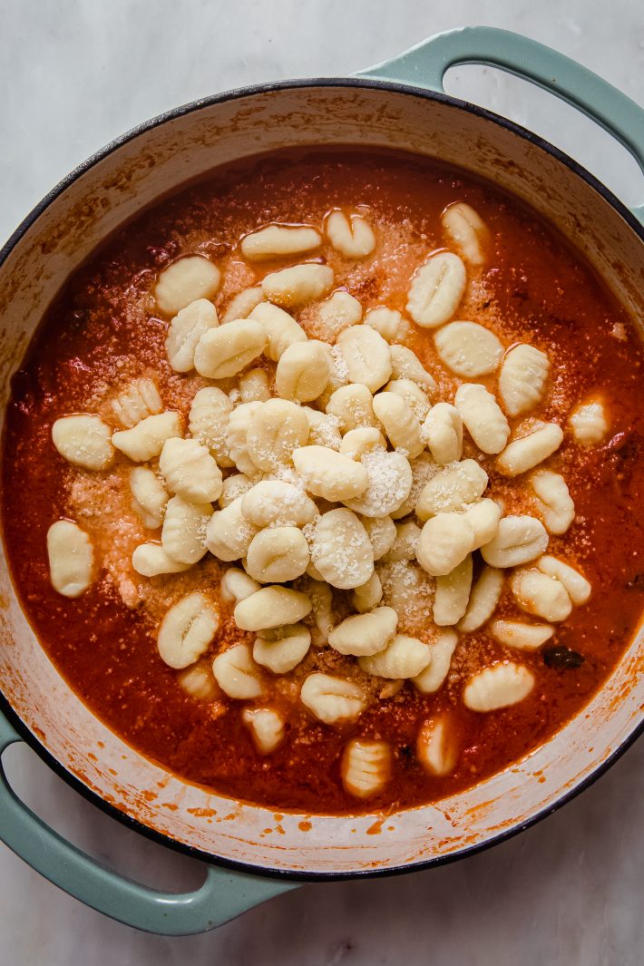pomodoro topped with dried gnocchi and parmesan in dutch oven