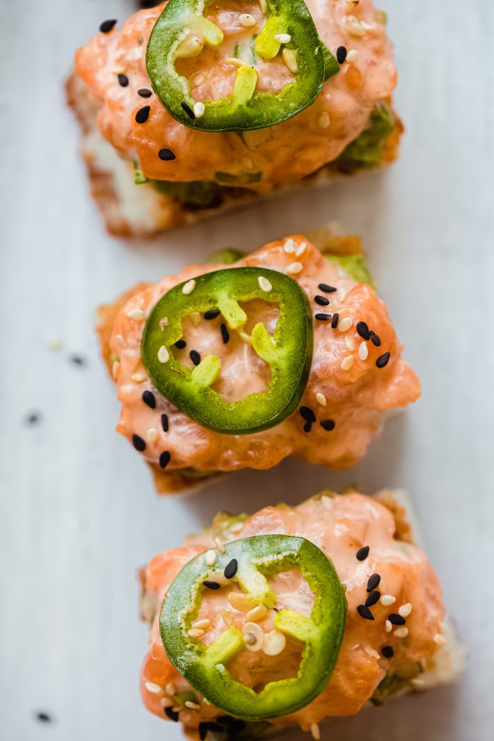 spicy salmon on crispy rice cakes topped with jalapeno