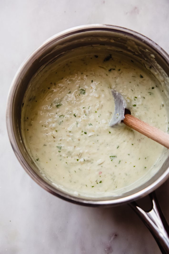 prepared tomatillo cream sauce in sauce pan with wooden spoon