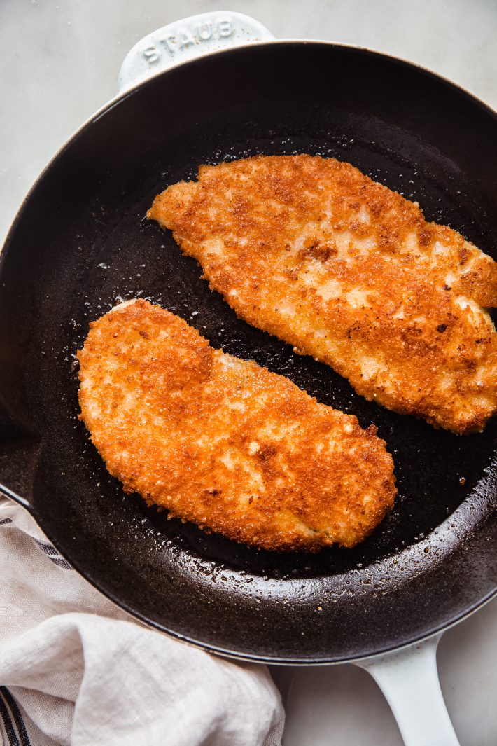 chicken cutlets in cast iron frying pan
