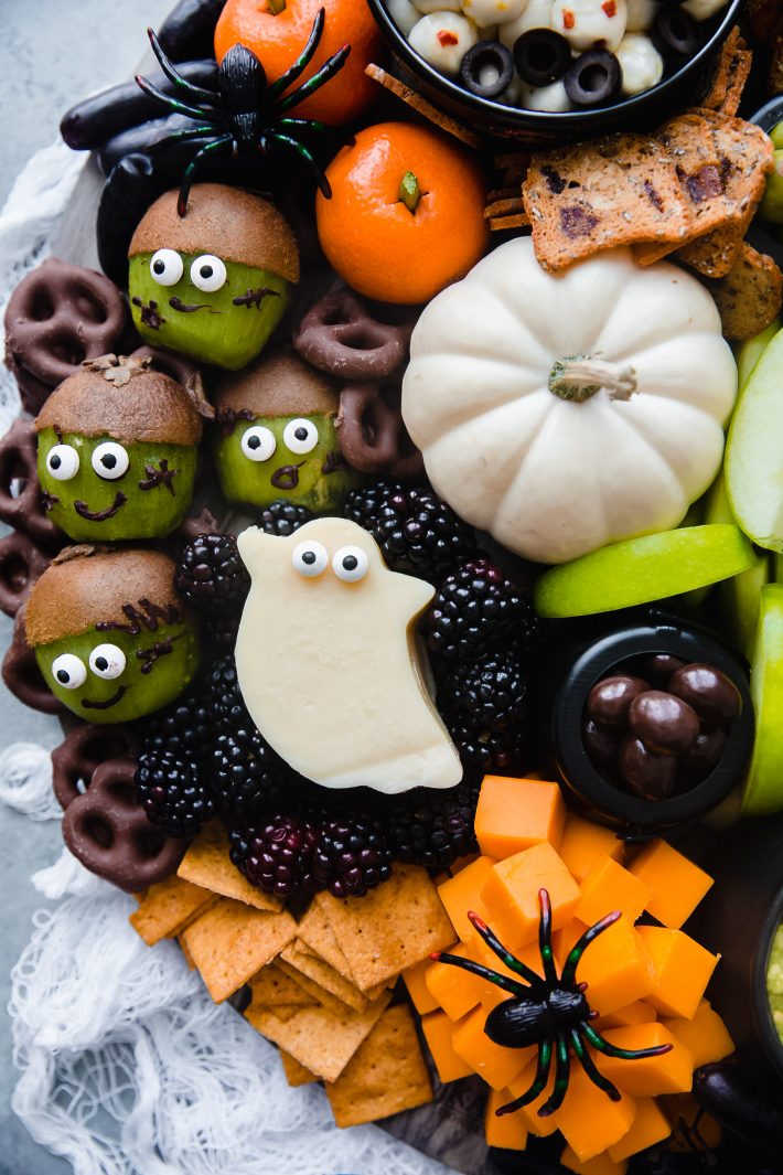 blackberries with a ghost cut out of cheese with candy eyeballs