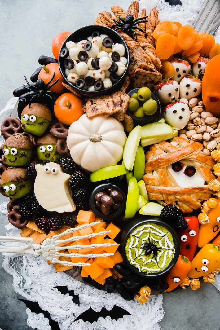 close up of halloween snack board with tons of orange, black, and green food items