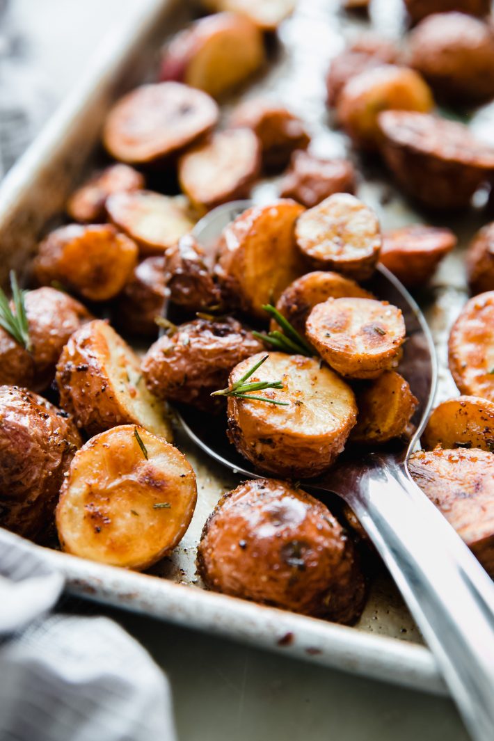 rosemary roasted potatoes on sheet pan with metal spoon