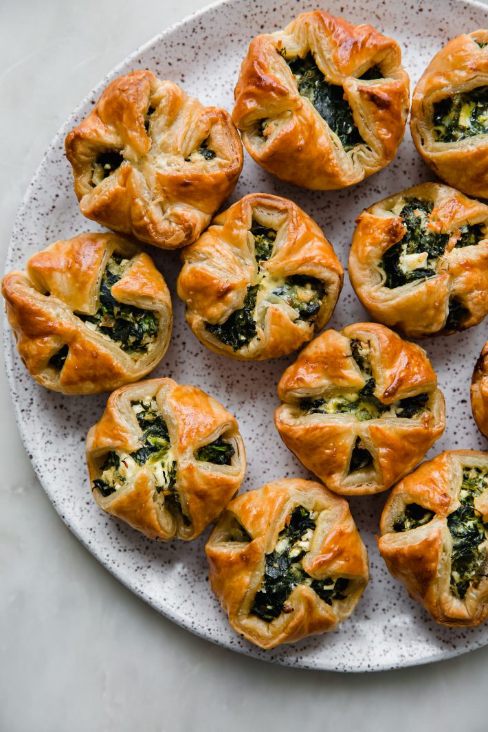 prepared spinach puffs lined up on plate