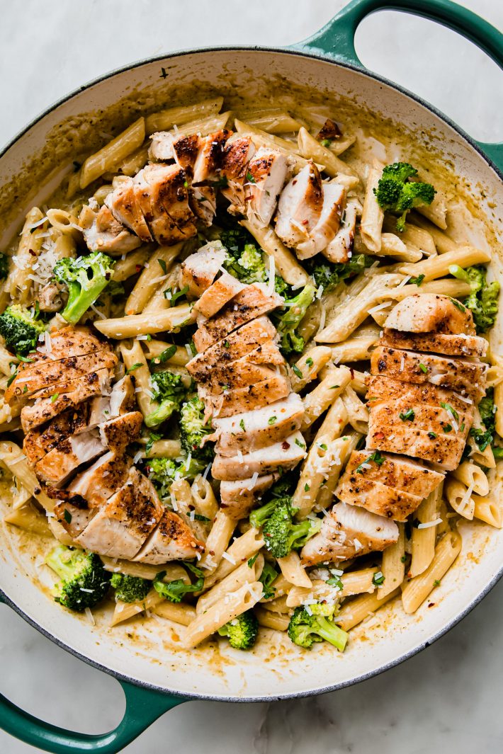 creamy pesto pasta topped with chicken and parmesan