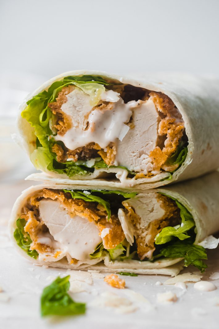 sliced wrap showing chicken with dressing, lettuce, and chicken tenders