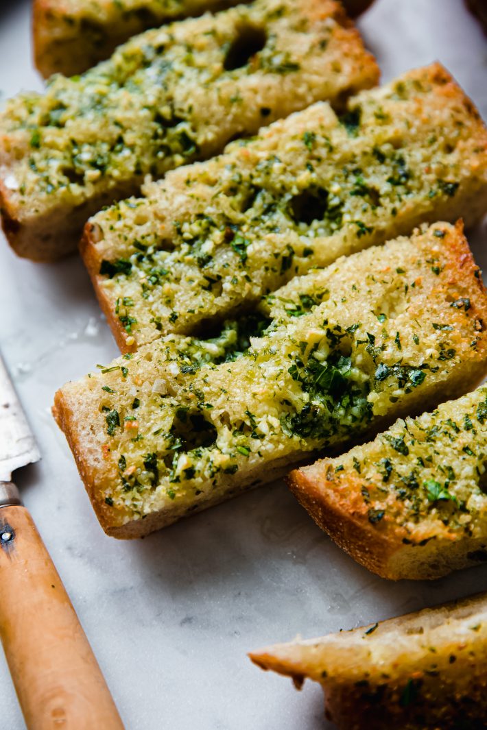 parsley topped garlic bread with knife