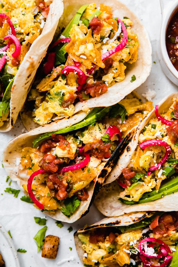 Migas breakfast tacos topped with salsa, and pickled red onions