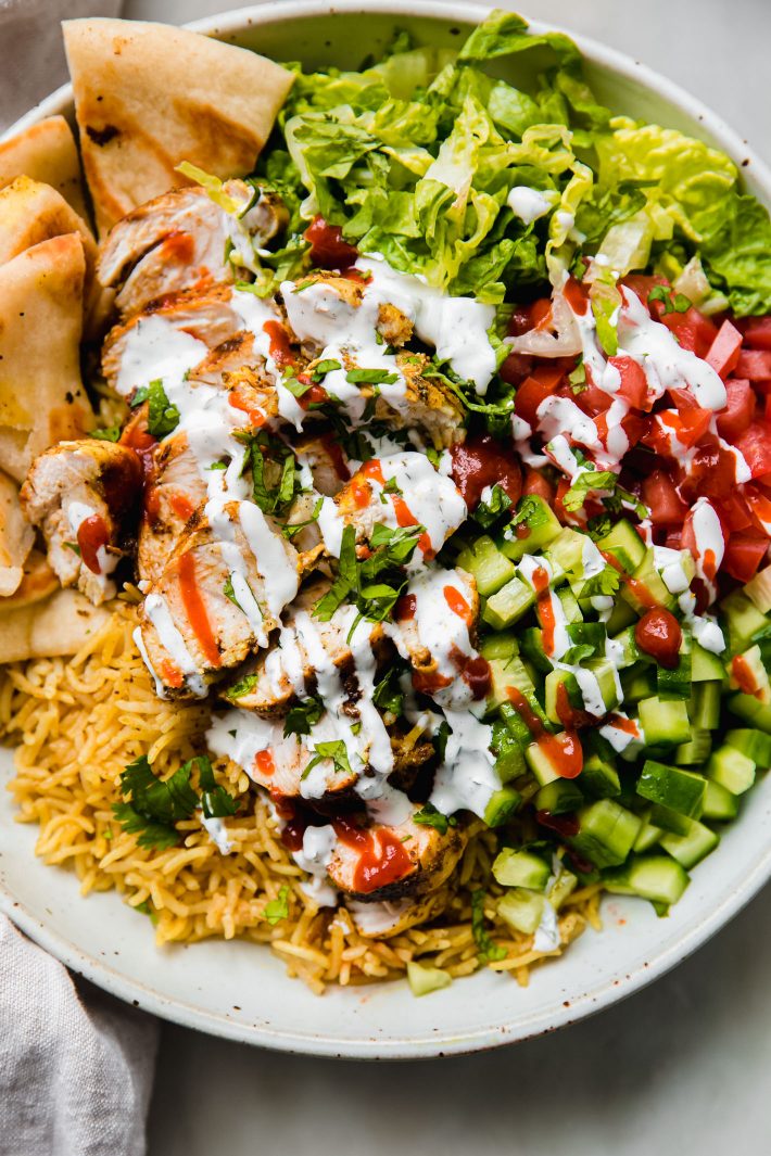 chicken and rice bowls with white sauce and red sauce