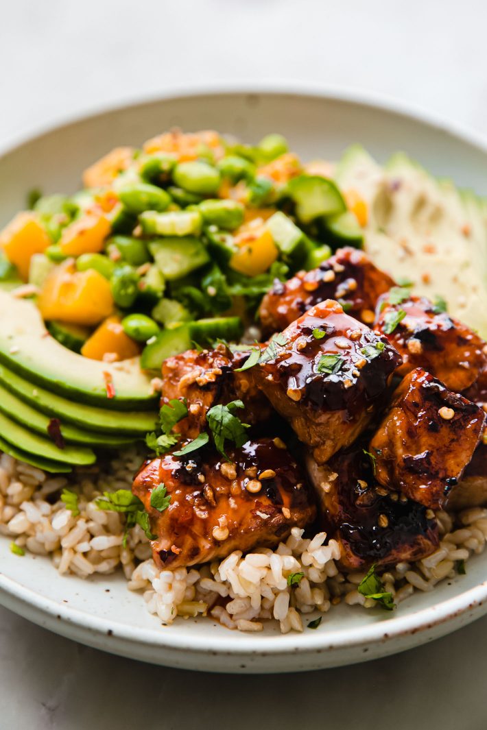 Glazed salmon nuggets over brown rice with avocados and mango salsa