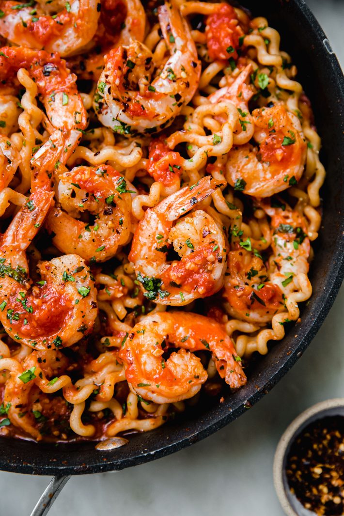 shrimp over pasta in tomato sauce in pan
