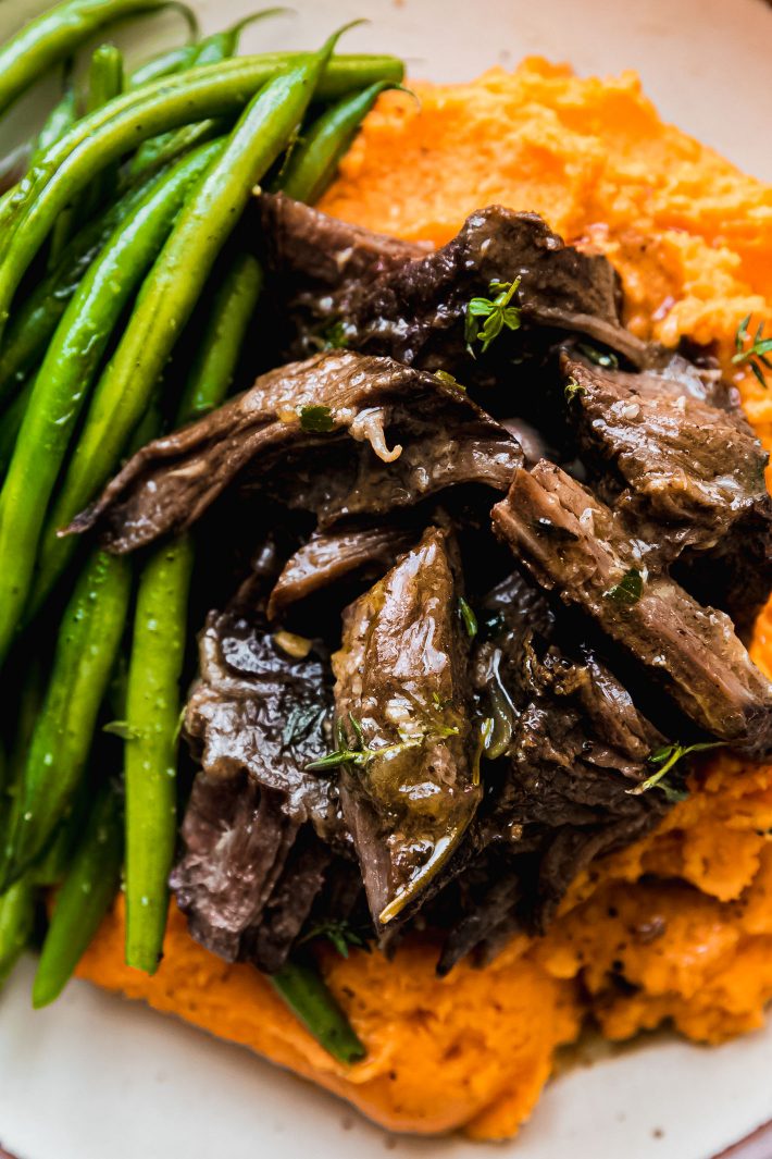 gravy soaked shredded beef over potatoes with green beans