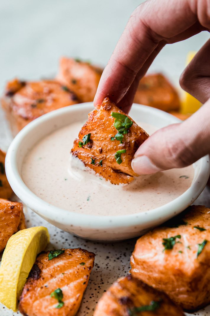 dipping air fryer salmon bites in remoulade sauce