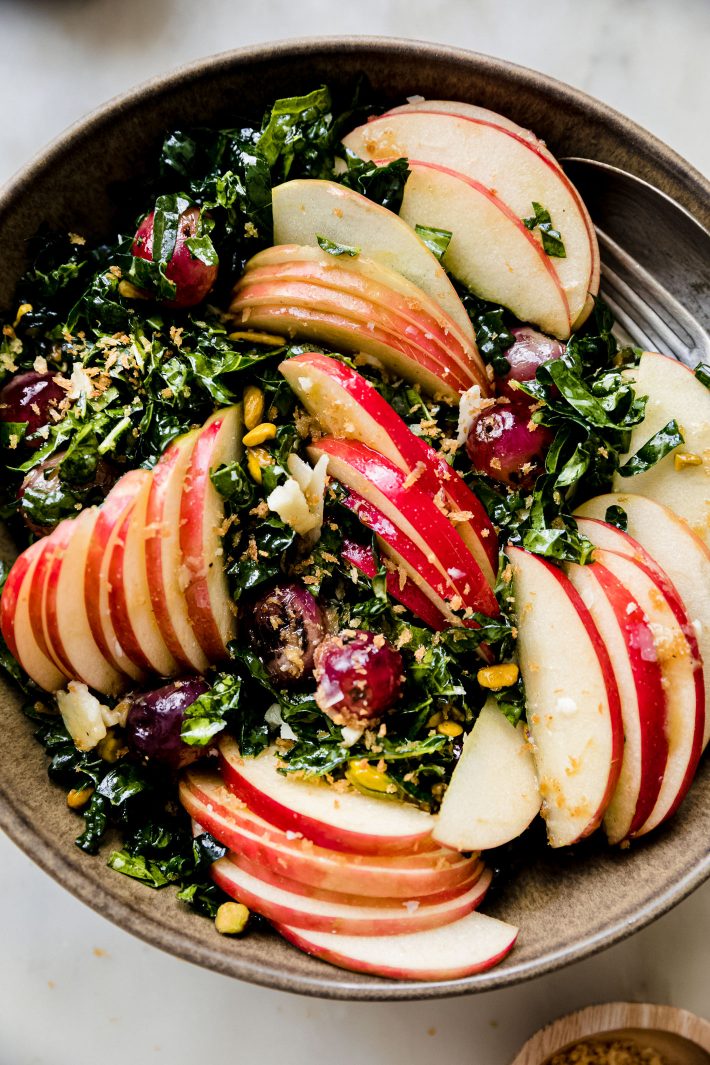 honeycrisp kale salad topped with grapes, parmesan and breadcrumbs