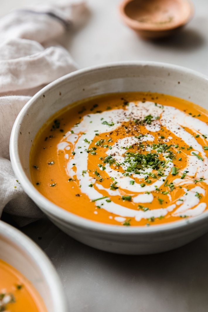 bowl of roasted squash soup topped with cream and chives