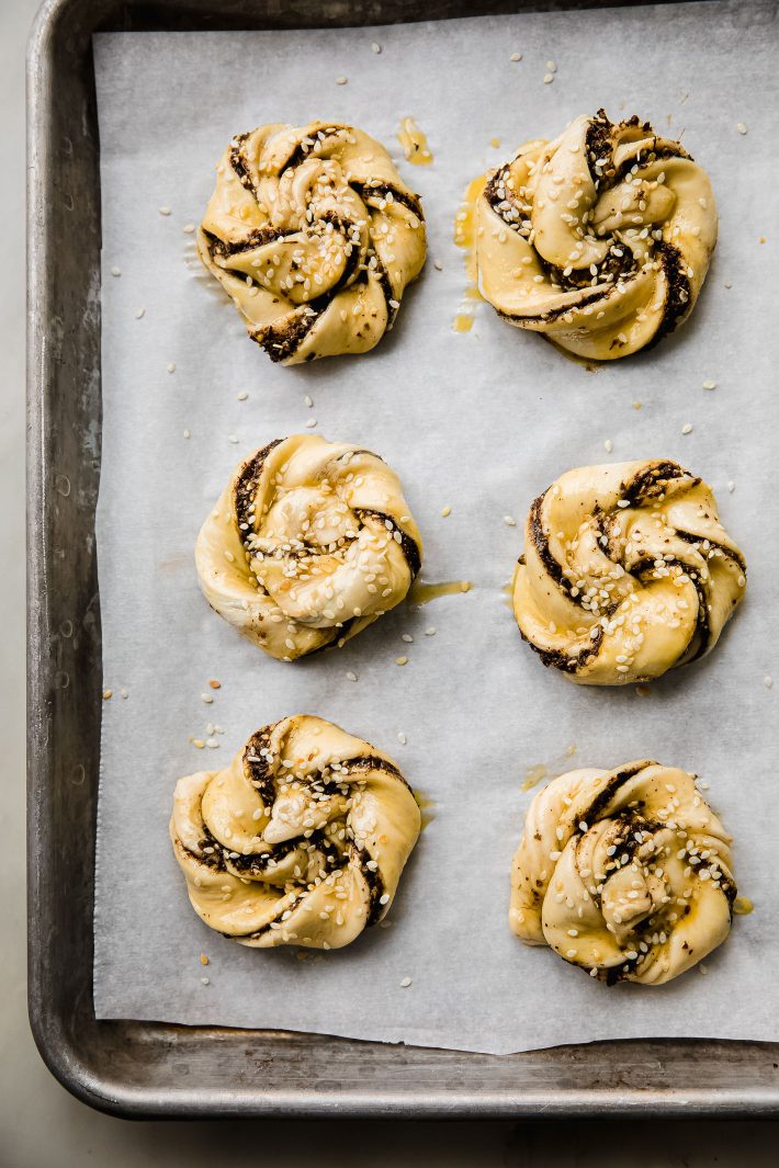 puff pastry swirls on sheet pan with egg wash and sesame seeds