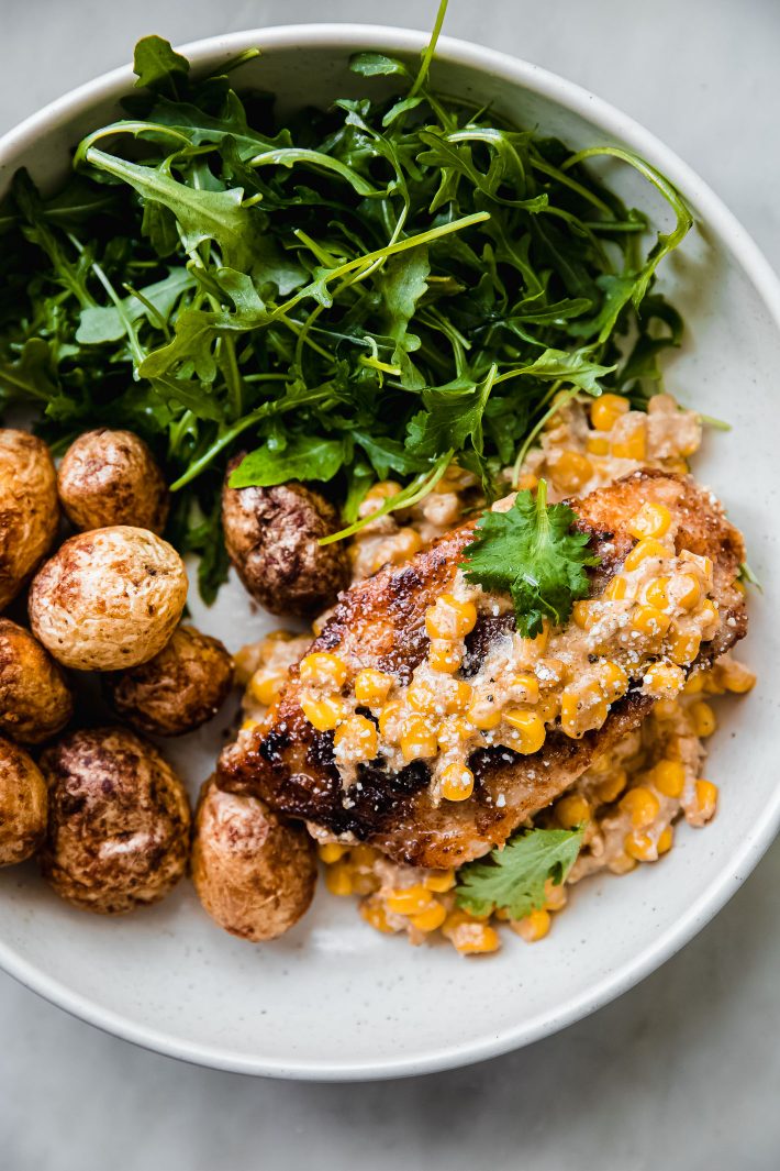 elotes corn chicken in bowls with potatoes and arugula