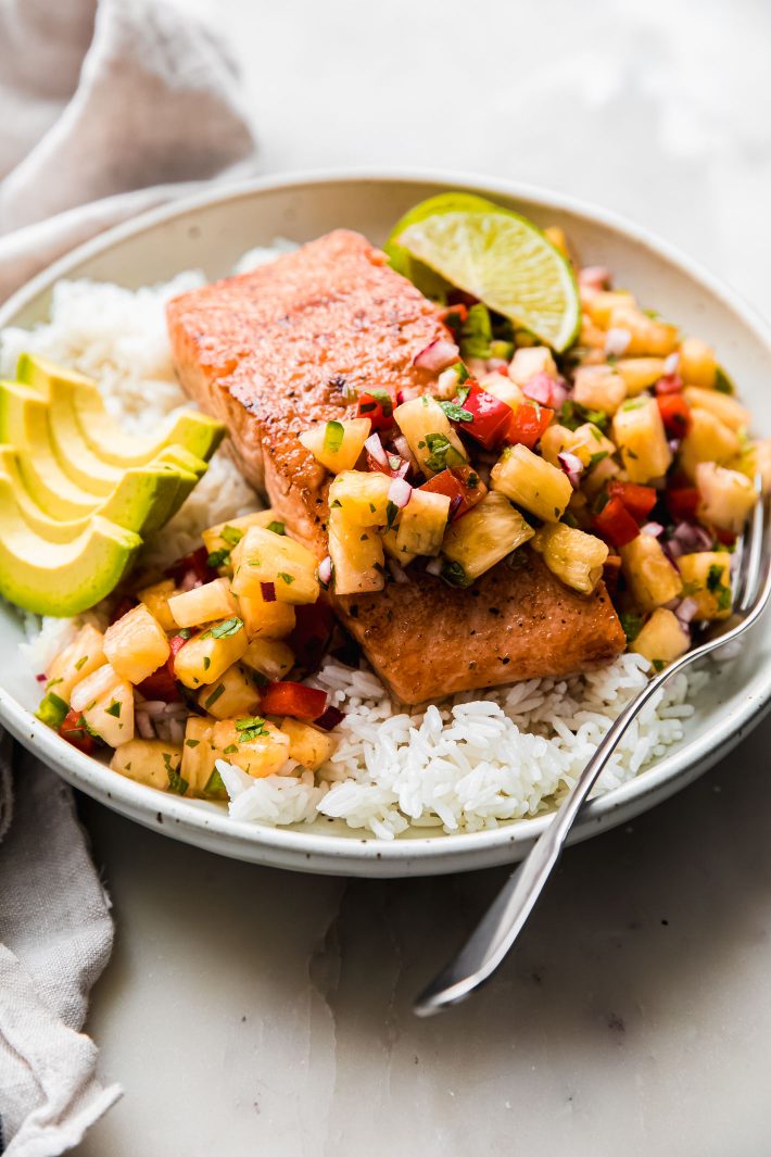 salmon with pineapple salsa and avocado slices over rice