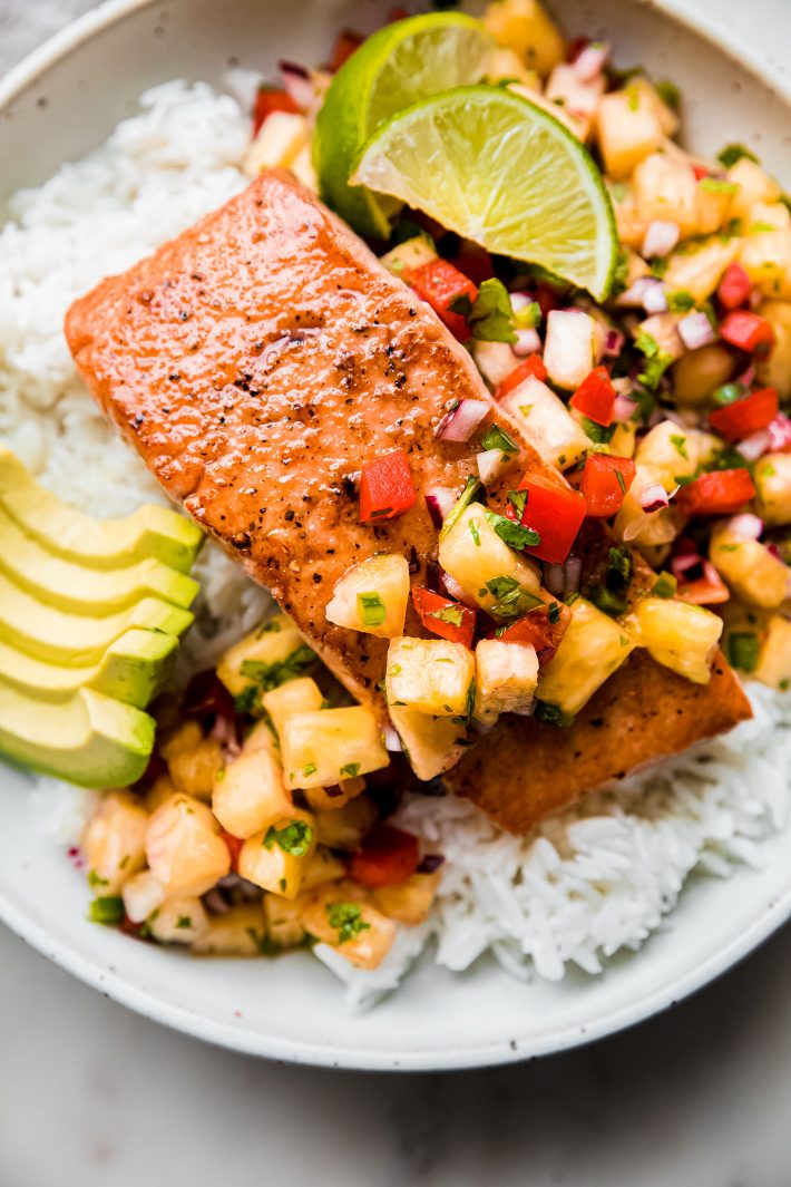 pineapple salsa salmon on a bed of white rice with limes and avocados