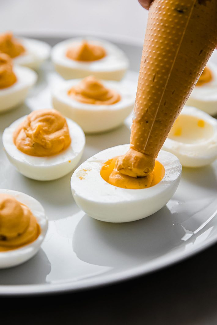 piping yolk mixture into egg whites