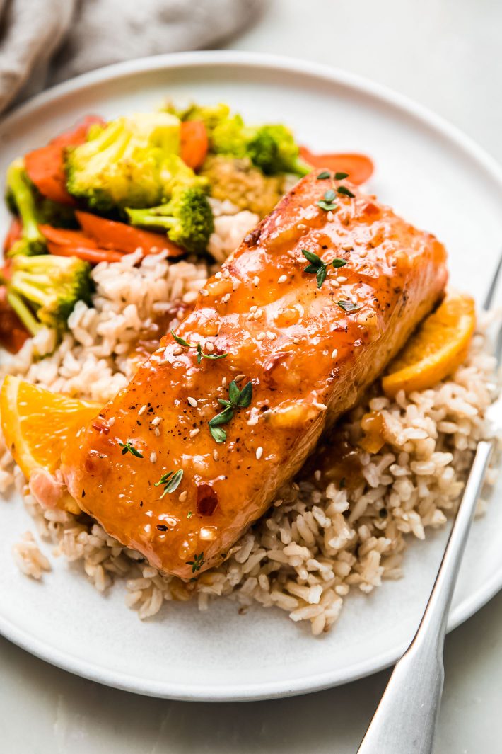 citrus glazed salmon on plate with brown rice and sautéed veggies