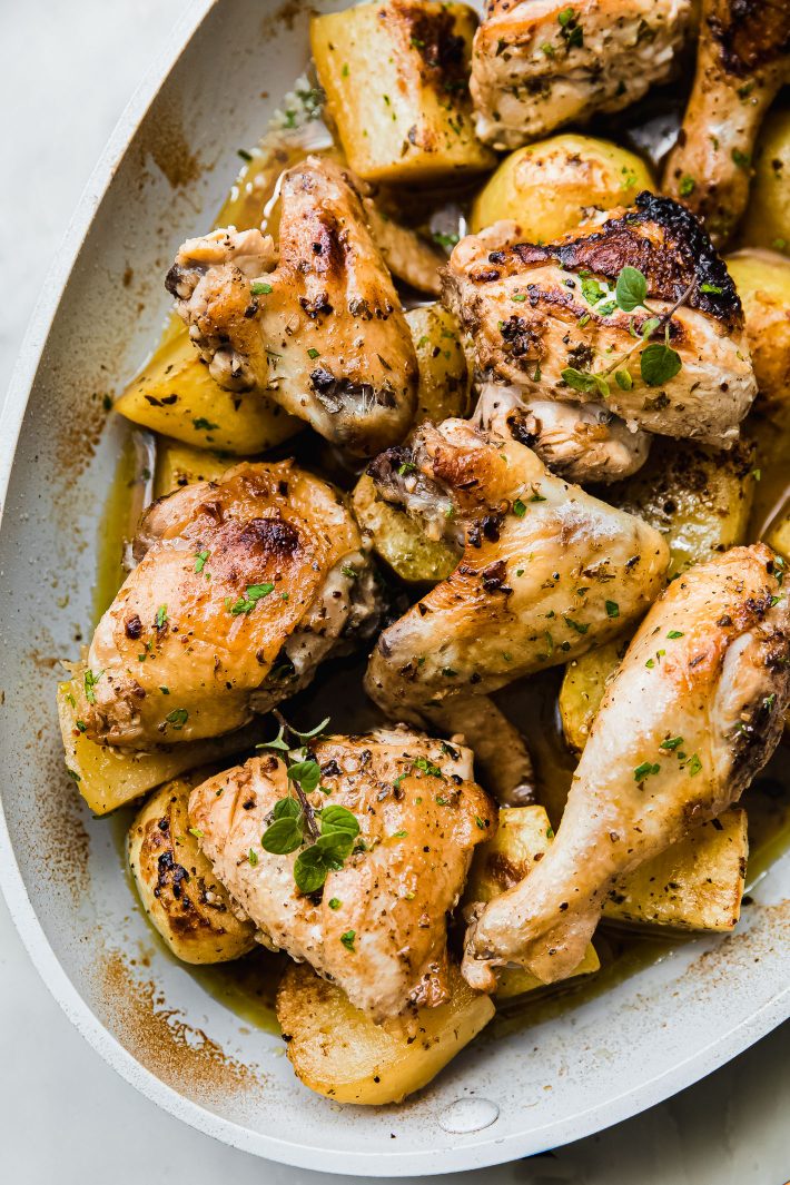 roasted chicken pieces in pan over lemon potatoes