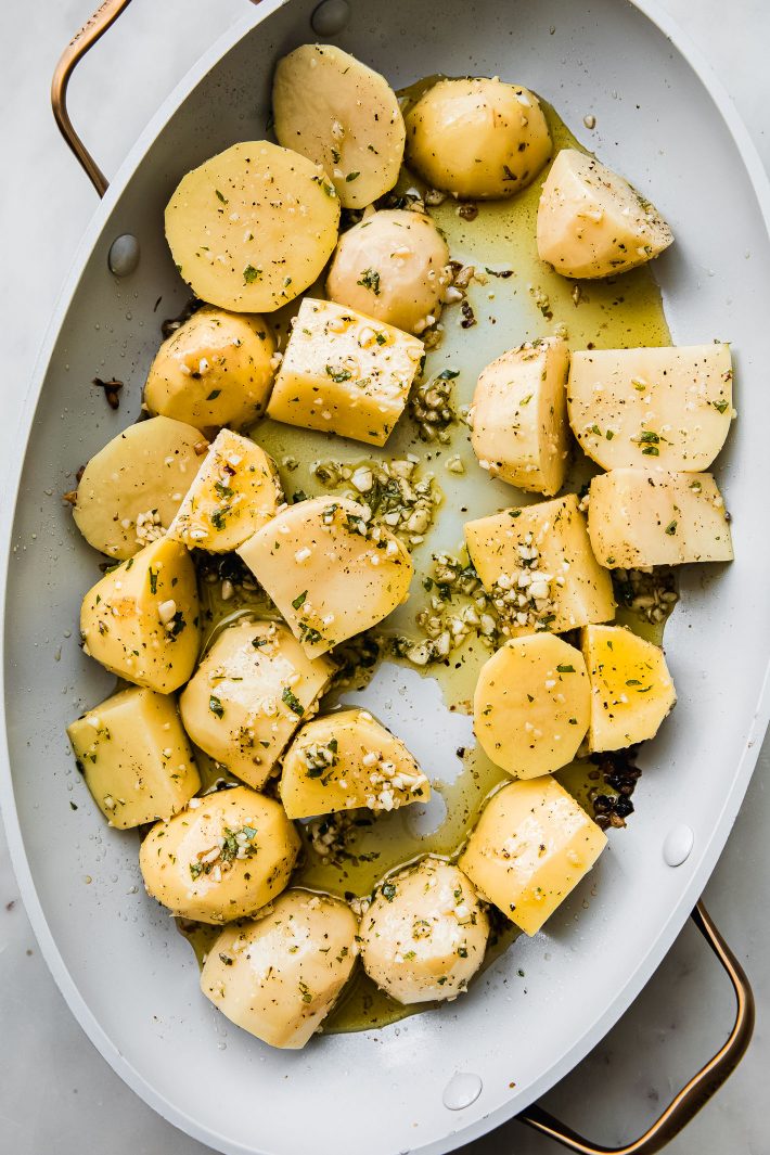 potatoes in roasting pan with oregano and garlic