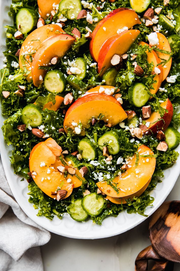 peach goat cheese salad with cucumbers over dressed kale