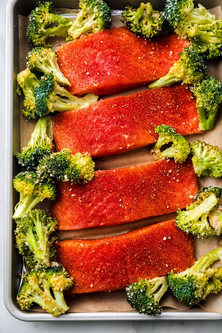 raw salmon and broccoli on baking sheet before roasting