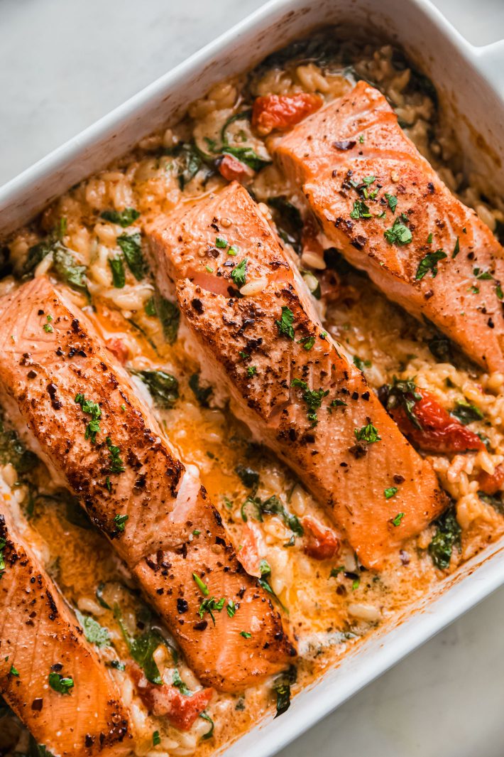 salmon with parsley over orzo in baking dish
