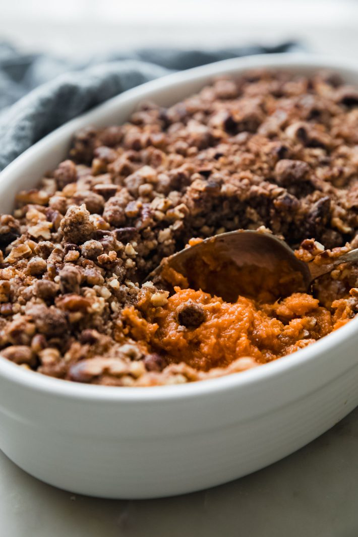 spoon in souffle dish with sweet potatoes showing