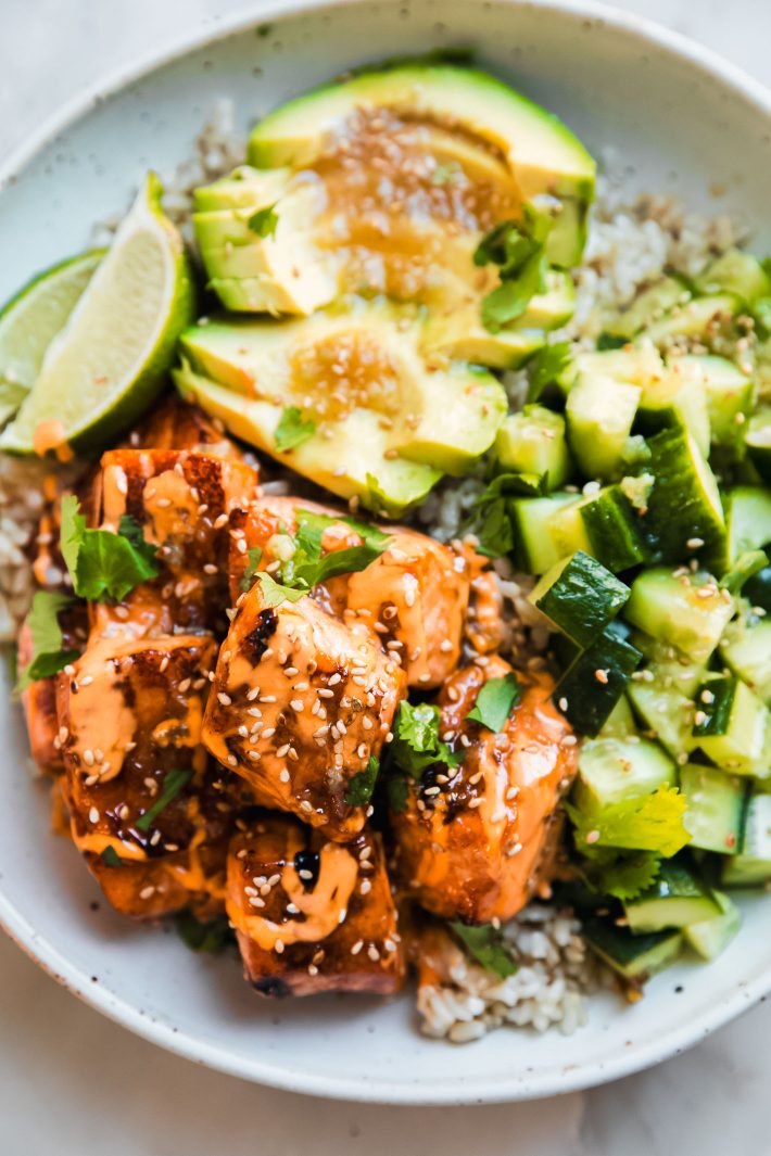 salmon bowls with avocado, cucumbers, and honey lime sauce