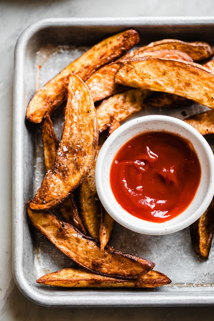 potato wedges on sheet pan with ketchup