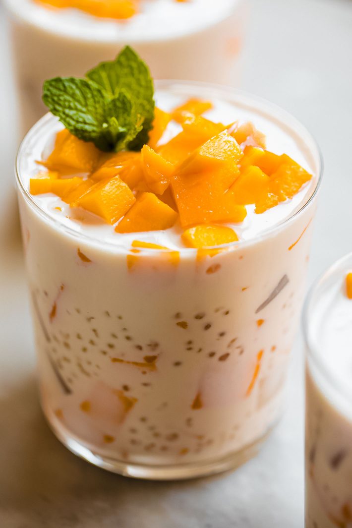 cup of Mango Bango dessert topped with mango chunks and a sprig of mint